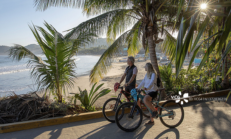 骑山地自行车的夫妇在沿海小路上放松图片素材