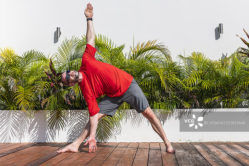 男子在户外露台上练习瑜伽图片素材