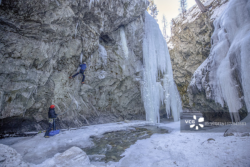 年轻男子攀登陡峭冰瀑图片素材