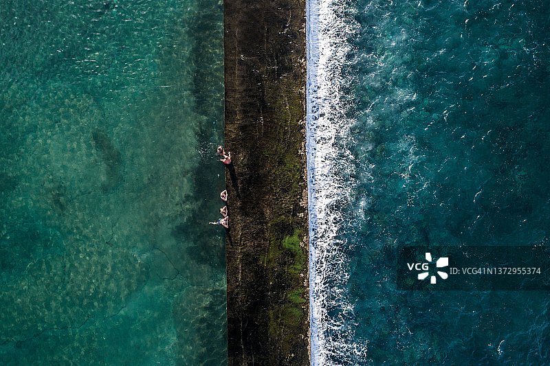 西班牙特内里费岛：潮汐池中的五个人（垂直视角）图片素材