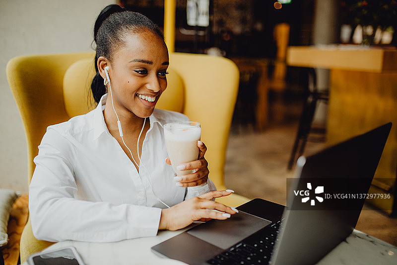 年轻女子在咖啡店喝咖啡并上网图片素材