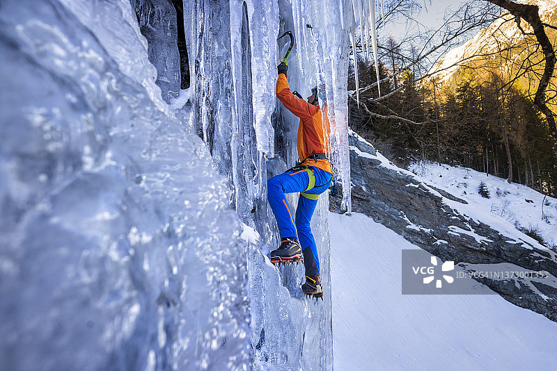 男子攀登冰冻的冰瀑图片素材