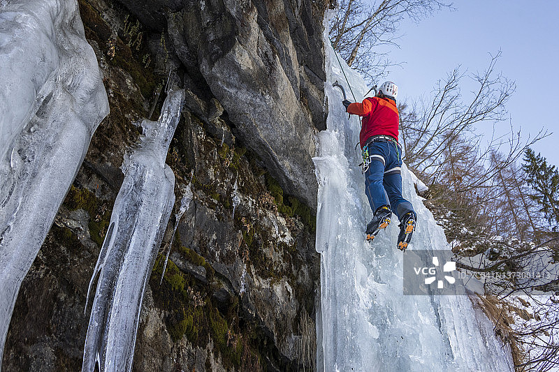 男子攀登冰冻的冰瀑图片素材