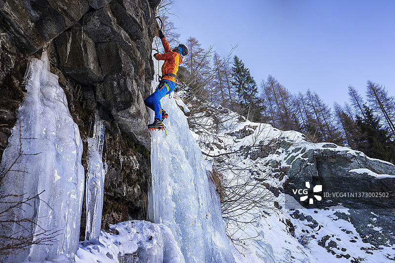 男子攀登冰冻的冰瀑图片素材
