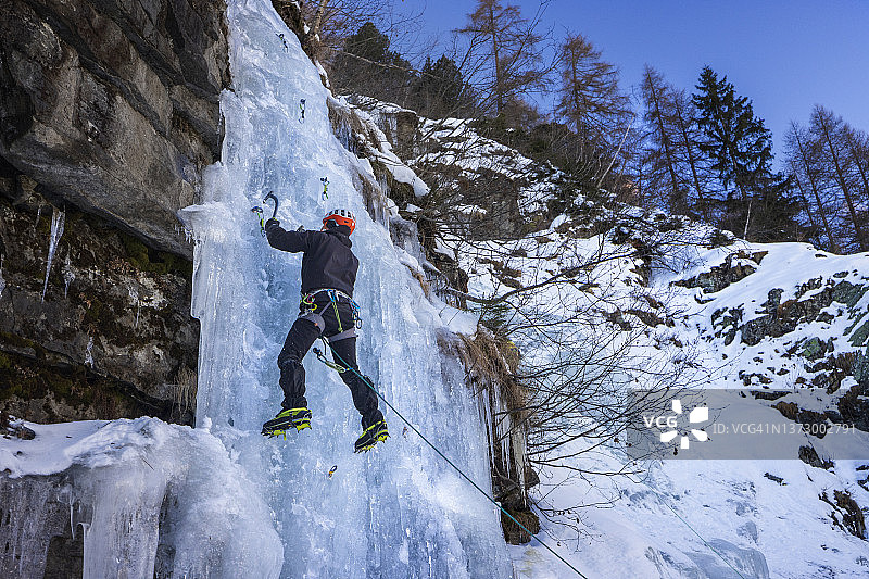 男子攀登冰冻的冰瀑图片素材
