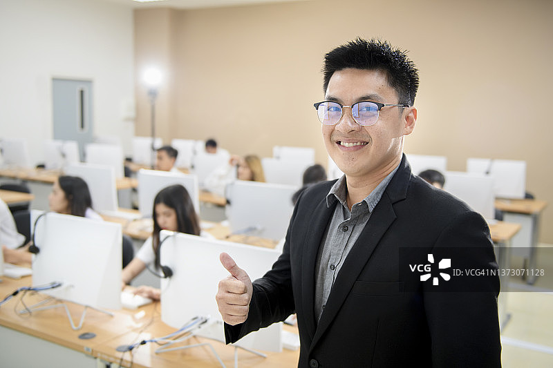 微笑的男性大学教授暂停工作拍照图片素材