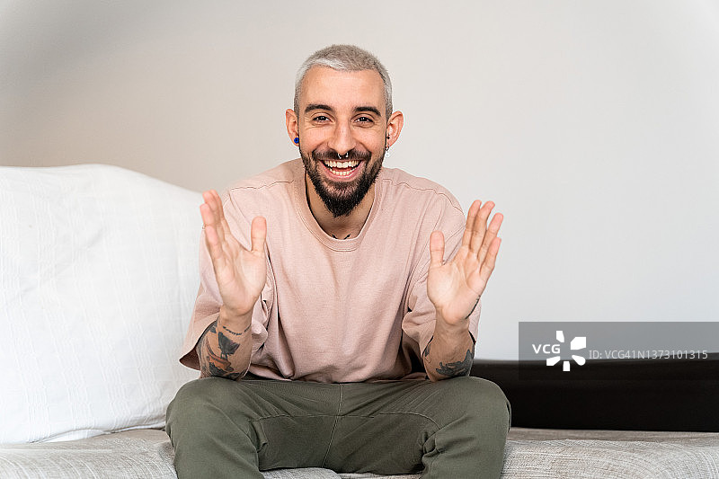 微笑的男人在家中进行视频通话或录制视频时对着镜头说话图片素材