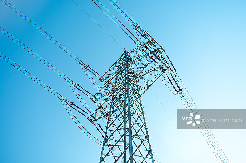 蓝天下高压线电杆：能源转型、能源转换、可持续能源、绿色能源、清洁能源基础设施图片素材