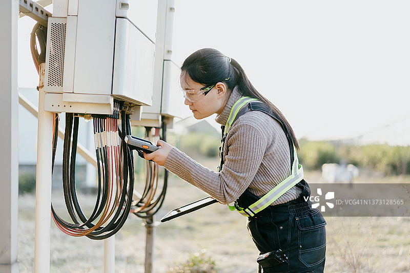 在太阳能发电站工作的亚洲女工程师图片素材