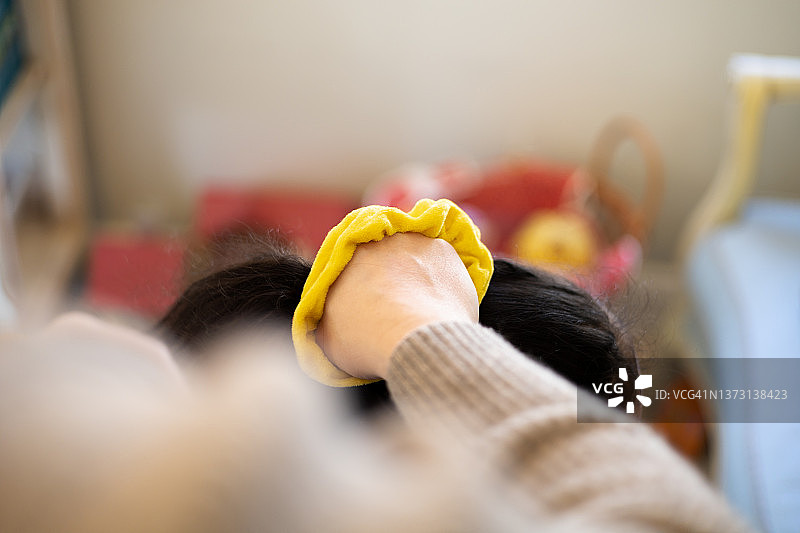 爸爸用亮黄色发圈给混血女儿扎马尾辫图片素材