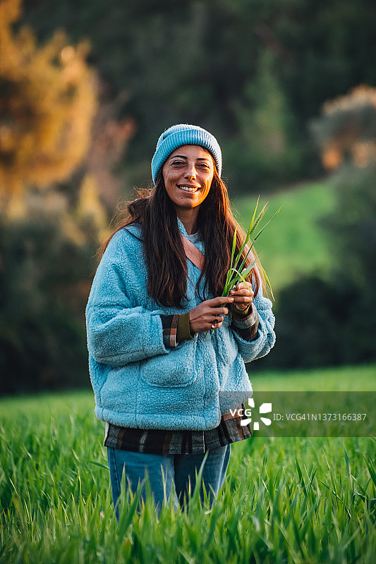 手持麦穗的麦田里的女人图片素材