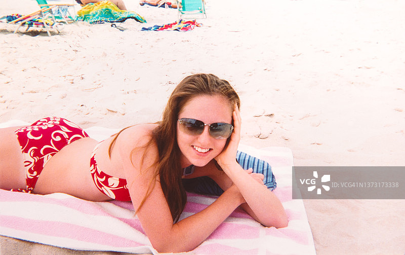 身穿比基尼、戴墨镜的女子在日光浴，Y2K千禧风图片素材