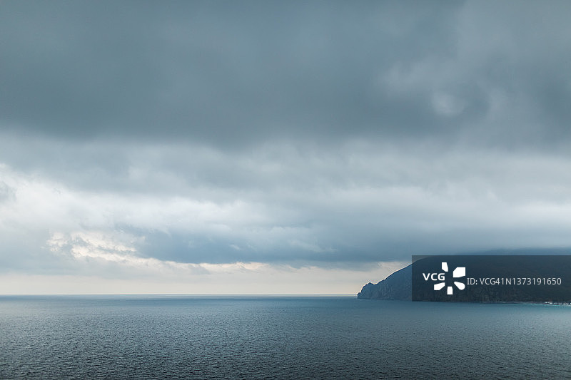 浅蓝色和灰色调的平静海景，低沉的云，留白背景图片素材