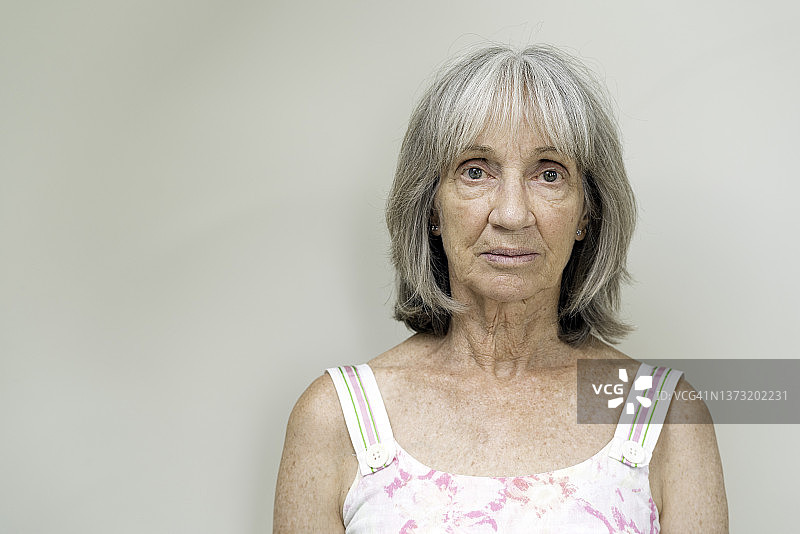 迷人的、面无笑容的年老女性的头肩肖像图片素材