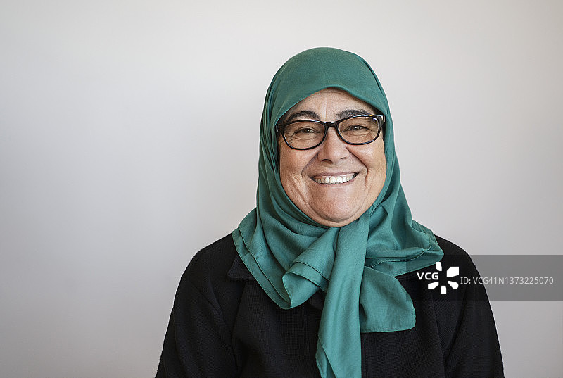 戴绿色头巾的老年妇女居家肖像图片素材