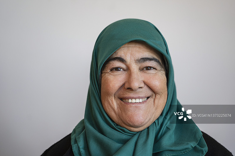 戴绿色头巾的老年妇女居家肖像图片素材