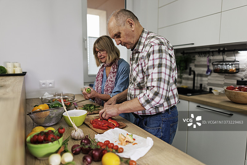 老年夫妇在家准备健康蔬菜沙拉图片素材