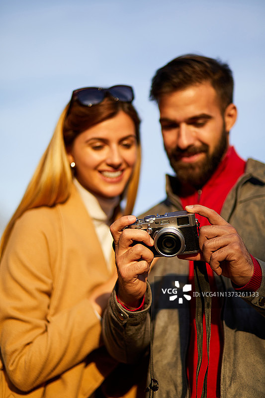 幸福的夫妇在户外查看相机上的照片图片素材