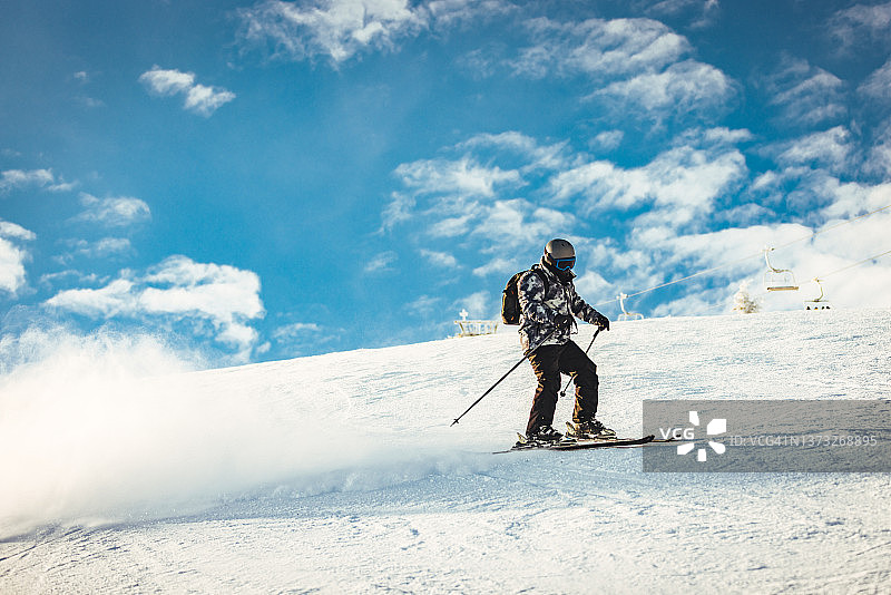 一位成年自由滑雪者在厚厚的雪地中滑下图片素材