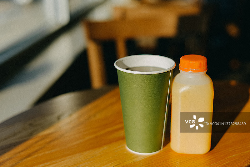 木桌上的纸杯和回收塑料瓶图片素材