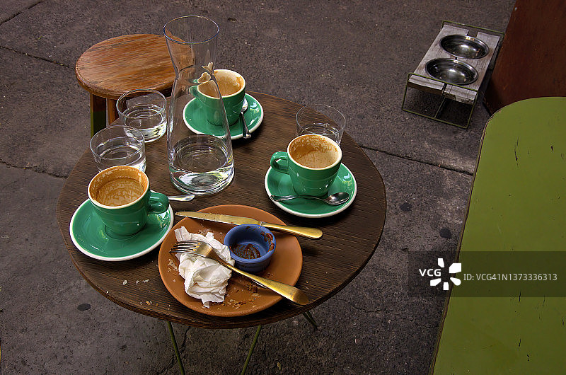 咖啡和小吃过后的凌乱的市中心人行道咖啡桌图片素材