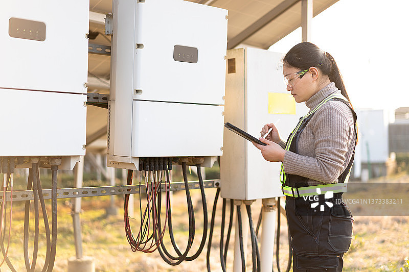 在太阳能发电站工作的亚洲女工程师图片素材
