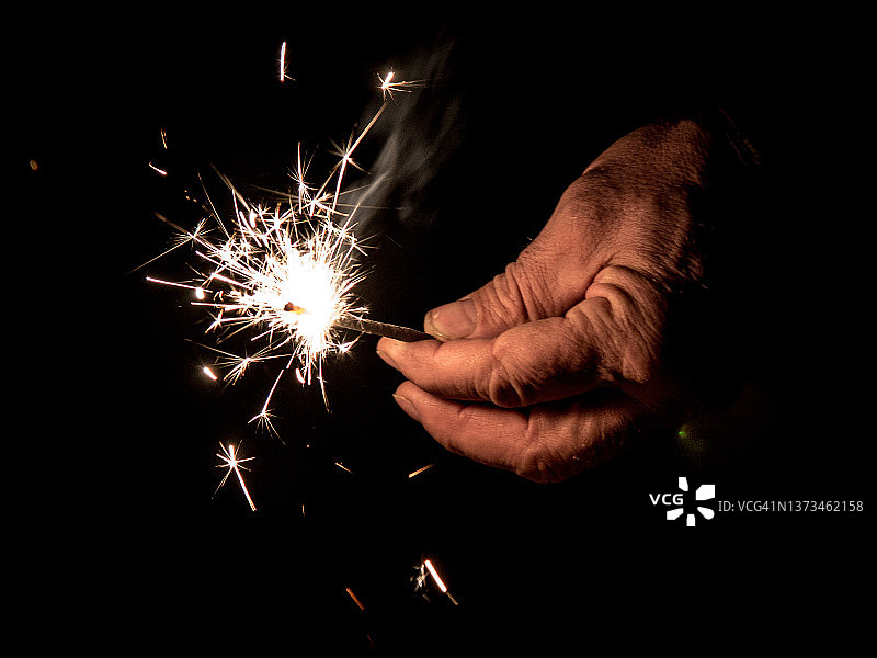老手拿着烟花棒图片素材