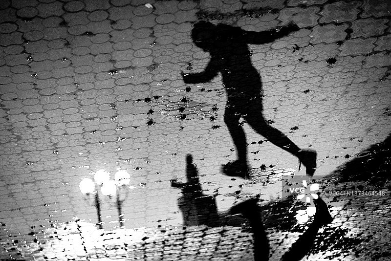 女孩跳过水坑的轮廓图片素材