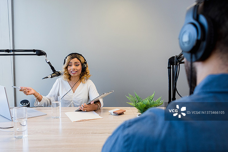 广播节目女主持人进行采访的肩部视角图片素材