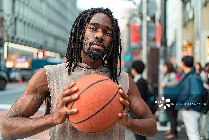 在城市里拿着篮球的英俊黑人男子肖像图片素材