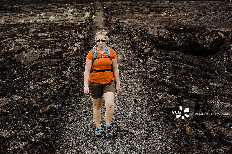 女人在夏威夷偏远的熔岩区徒步图片素材