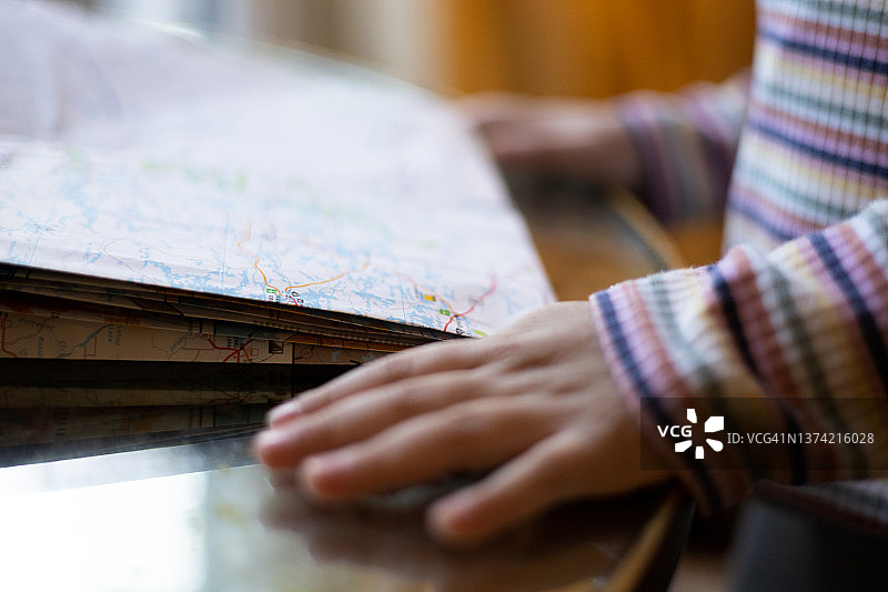 年轻混血女孩喜欢在家人准备公路旅行时学习阅读纸质地图图片素材