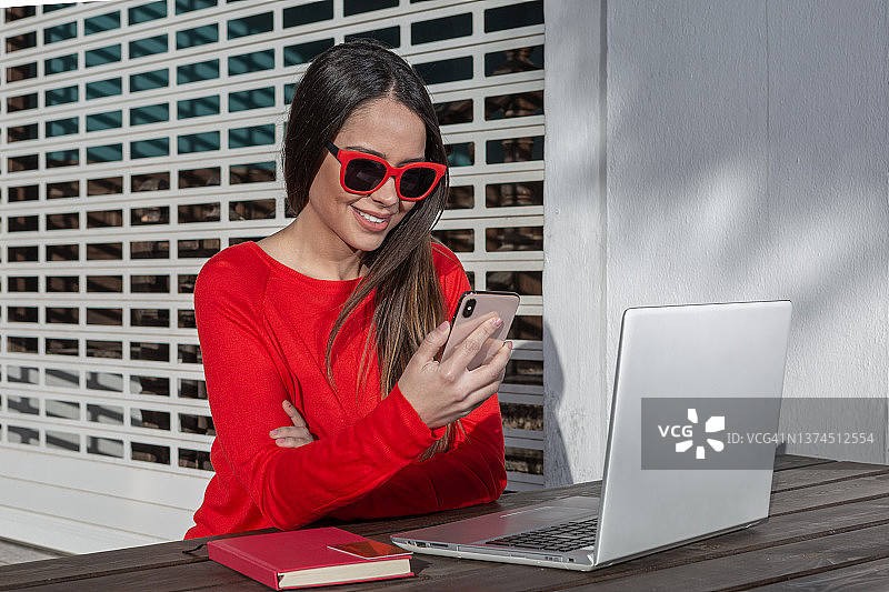 女人在城市远程工作时使用智能手机图片素材