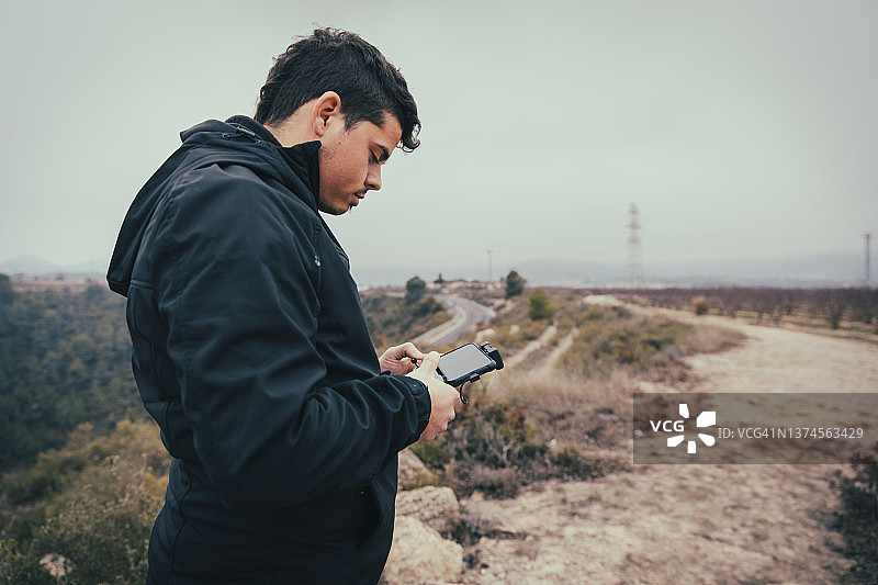 在户外放飞无人机的男孩侧面照图片素材