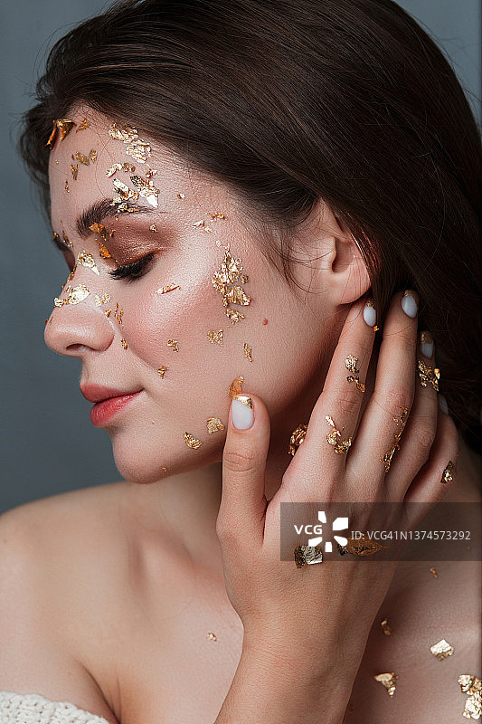 拥有金色美甲的女孩的侧脸美容肖像图片素材