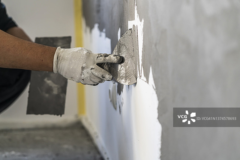 在混凝土墙面上工作的人手特写图片素材