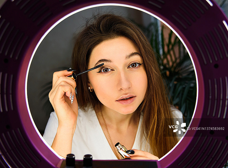 年轻漂亮的女人展示如何化妆图片素材