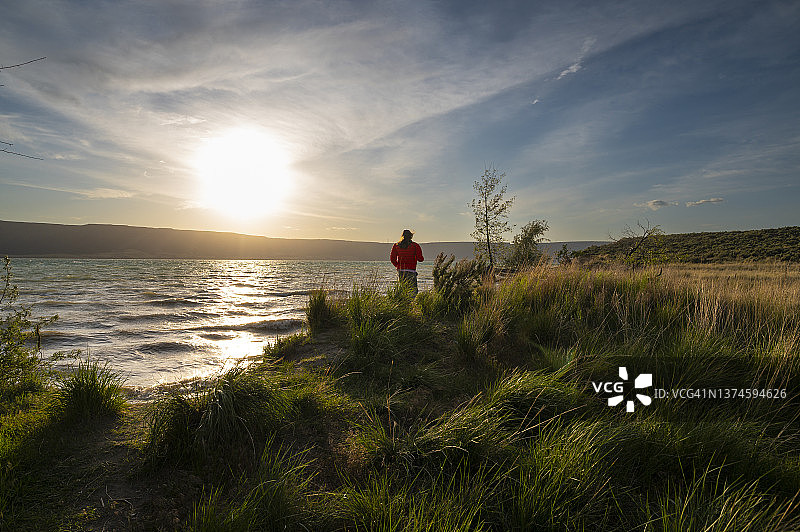 日落时分，一名女子走在班克斯湖畔图片素材
