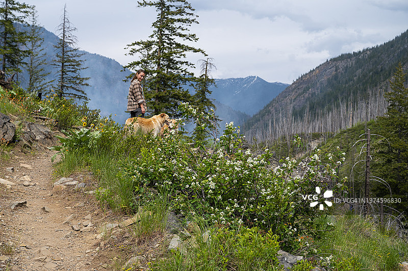 在北喀斯喀特山脉与狗徒步的女子图片素材