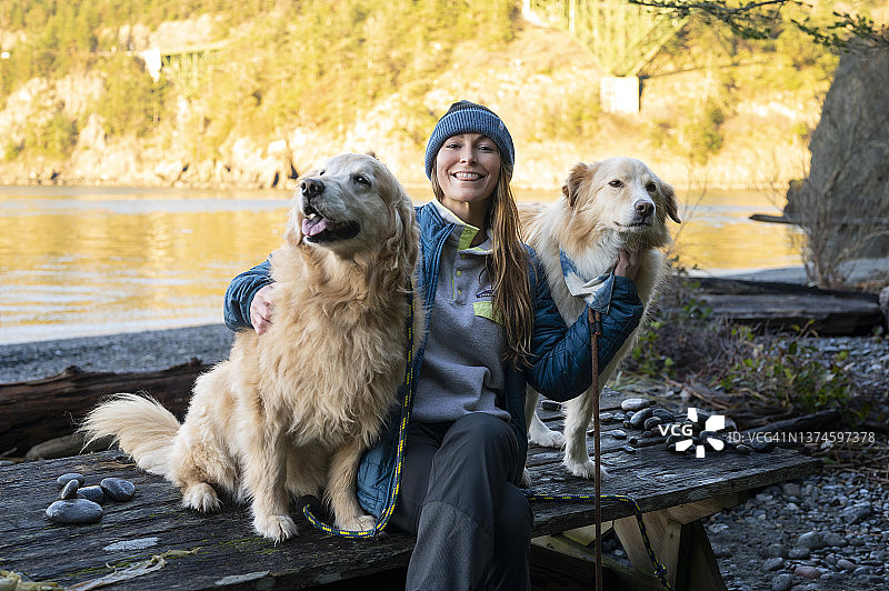 女人和狗坐在迪ception Pass州立公园的野餐桌旁图片素材