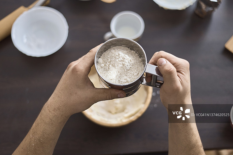 手中拿着筛子的男人的手的俯视图图片素材