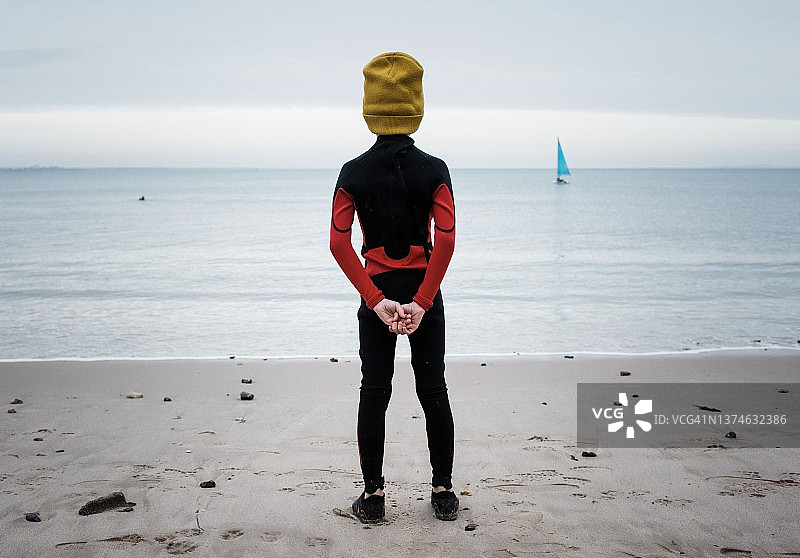 准备冷水游泳、看着大海的少年图片素材