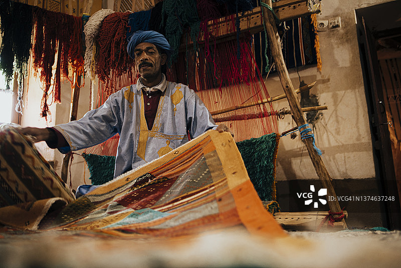 阿拉伯手工编织地毯商贩正面照图片素材