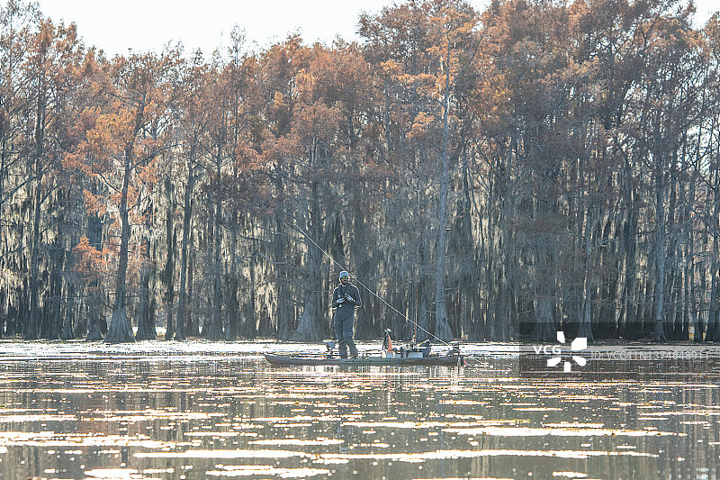 男人在秋天的湖上钓鱼图片素材