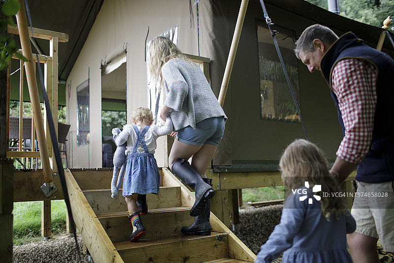 一家人手牵着手走上小屋的台阶图片素材