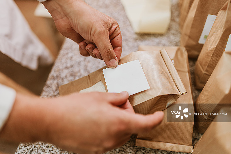 工厂里往纸袋上贴标签的男人图片素材