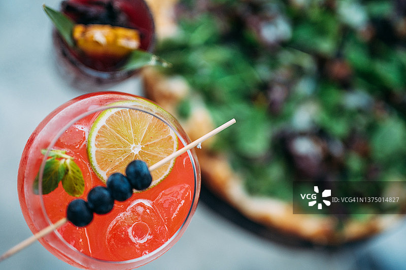 披萨旁的红色鸡尾酒俯视图图片素材