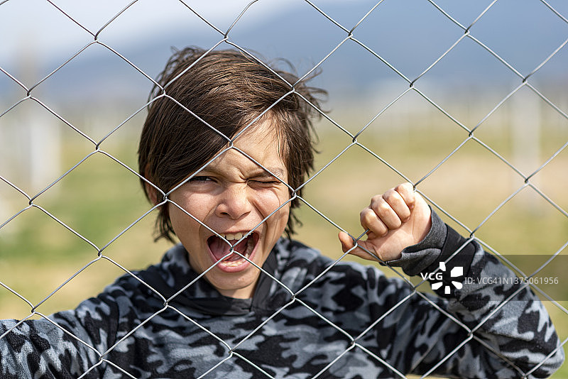 在栅栏后面的小男孩图片素材