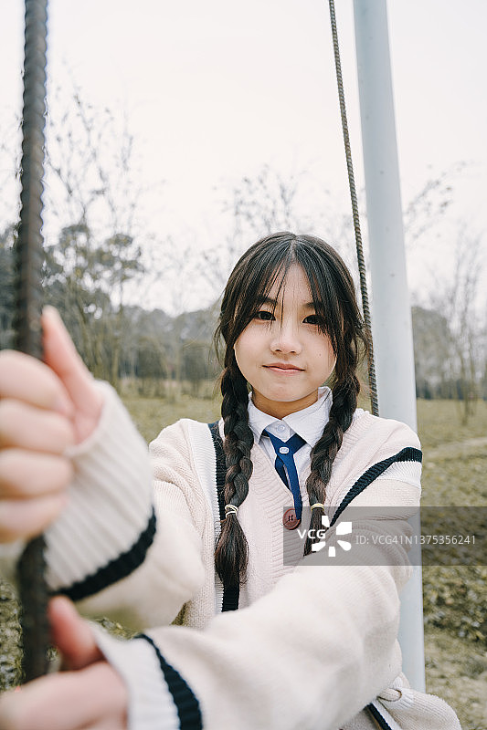 在秋千上快乐玩耍的亚洲女孩图片素材