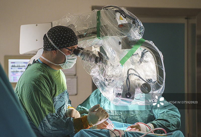 在医院手术室进行脑肿瘤手术的男神经外科医生团队图片素材